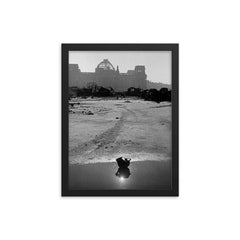 A Broken German Stahlhelm in a Puddle with Reichstag Ruins, Berlin framed print on a plain backdrop in size 12"x16".