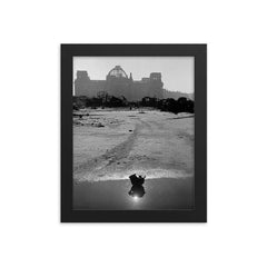 A Broken German Stahlhelm in a Puddle with Reichstag Ruins, Berlin framed print on a plain backdrop in size 8"x10".