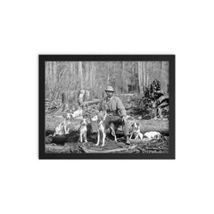 A deer hunter poses for a portrait with his hounds, 1897 framed print on a plain backdrop in size 12"x16".
