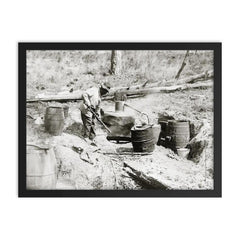 A man operating a moonshine still in a remote location - Texas, 1923 framed print on a plain backdrop in size 18"x24".