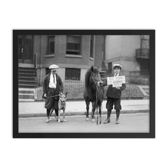 A portrait of boys posing with a dog and a pony and holding a sign announcing that it is 'Be Kind To Animals Week', 1923 framed print on a plain backdrop in size 18"x24".