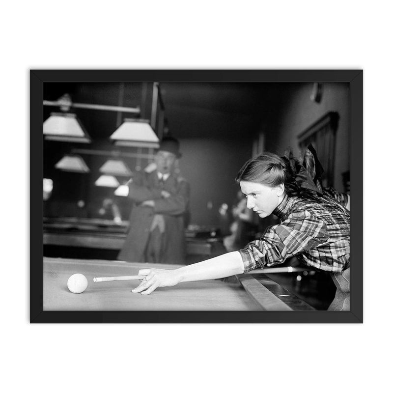 Billiards champ - a female champion billiards player lines up a shot, 1910 framed print on a plain backdrop in size 18