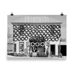 Firestone Tire Shop, 1940 - a used tire shop and filling station displaying tires from top to bottom San Marcos, Texas poster on a plain backdrop in size 8"x10".