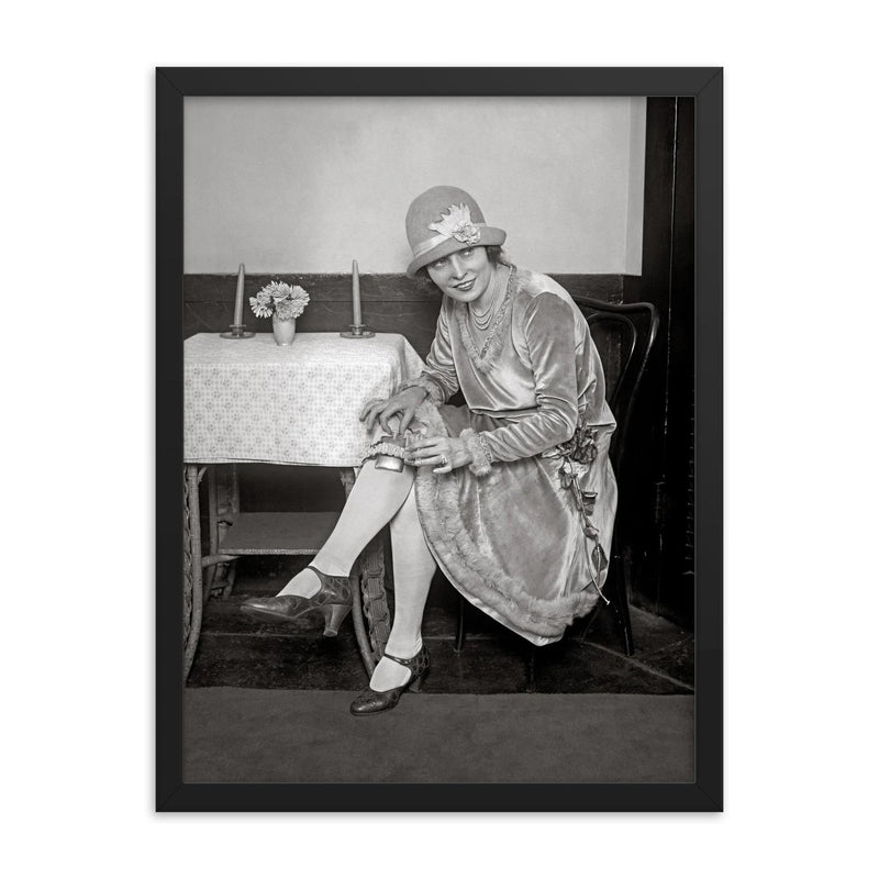 Flask Hidden in Garter, 1926 - A woman reveals a flask hidden in her garter during the Prohibition era framed print on a plain backdrop in size 18