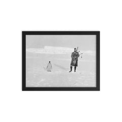 Gilbert Kerr bagpiping with an Emperor Penguin framed print on a plain backdrop in size 12"x16".