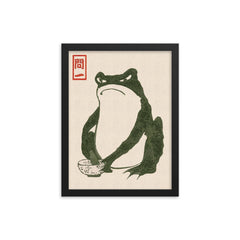 Grumpy Frog by Matsumoto Hoji framed print on a plain backdrop in size 12"x16".