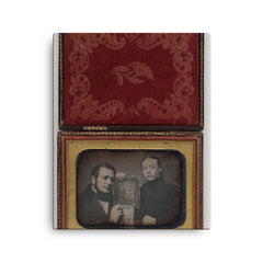 Man and Woman Posing with Family Daguerreotype, c. 1850 canvas print on a plain backdrop in size 16"x20".
