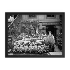 New York City flower shop, 1905 - A florist poses with a display of Easter flowers outside his shop framed print on a plain backdrop in size 18"x24".