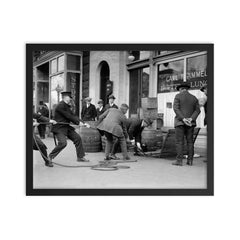 Police seizing bootleg liquor - Police haul barrels of illegal liquor from the basement of a speakeasy during the era of alcohol prohibition, 1923 framed print on a plain backdrop in size 16"x20".