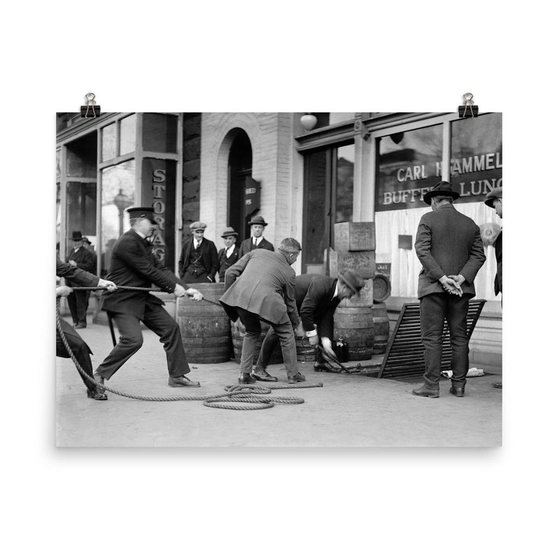 Police seizing bootleg liquor - Police haul barrels of illegal liquor from the basement of a speakeasy during the era of alcohol prohibition, 1923 poster on a plain backdrop in size 8