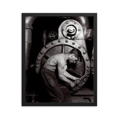 The Steamfitter, 1921 - Lewis Hines' iconic black and white photo of a power plant mechanic posed in front of a steam generator framed print on a plain backdrop in size 16"x20".
