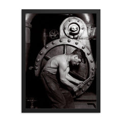 The Steamfitter, 1921 - Lewis Hines' iconic black and white photo of a power plant mechanic posed in front of a steam generator framed print on a plain backdrop in size 18"x24".