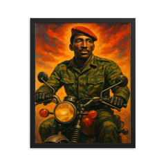 Thomas Sankara on motorcycle in fatigues framed print on a plain backdrop in size 16"x20".