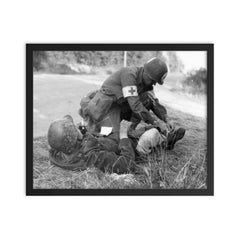 US Medic Providing First Aid to Wounded German Soldier, France 1944 framed print on a plain backdrop in size 16"x20".