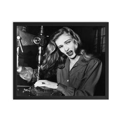 Veronica Lake Demonstrating the Risks of Long Hair for Women War Workers, November 9, 1943 framed print on a plain backdrop in size 16"x20".
