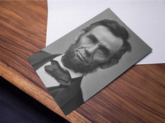 Close-up photo of an Abraham Lincoln poster print lying on a wooden table.