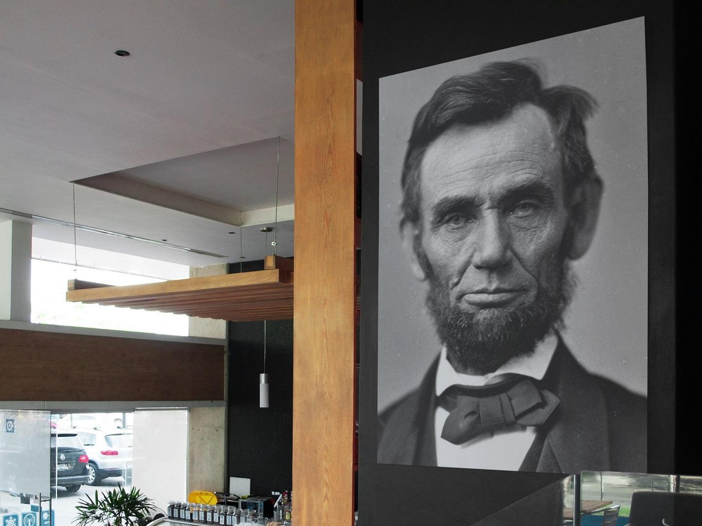 Abraham Lincoln poster print displayed on a wall in a coffee shop.
