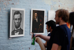 Abraham Lincoln poster print displayed in an art gallery with people talking about it.