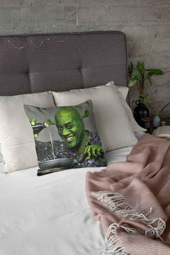 An Ainsley Harriott Shrek throw pillow on a bed with a white duvet.