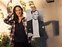 Young woman winking and holding up a Mustafa Kemal Ataturk print.