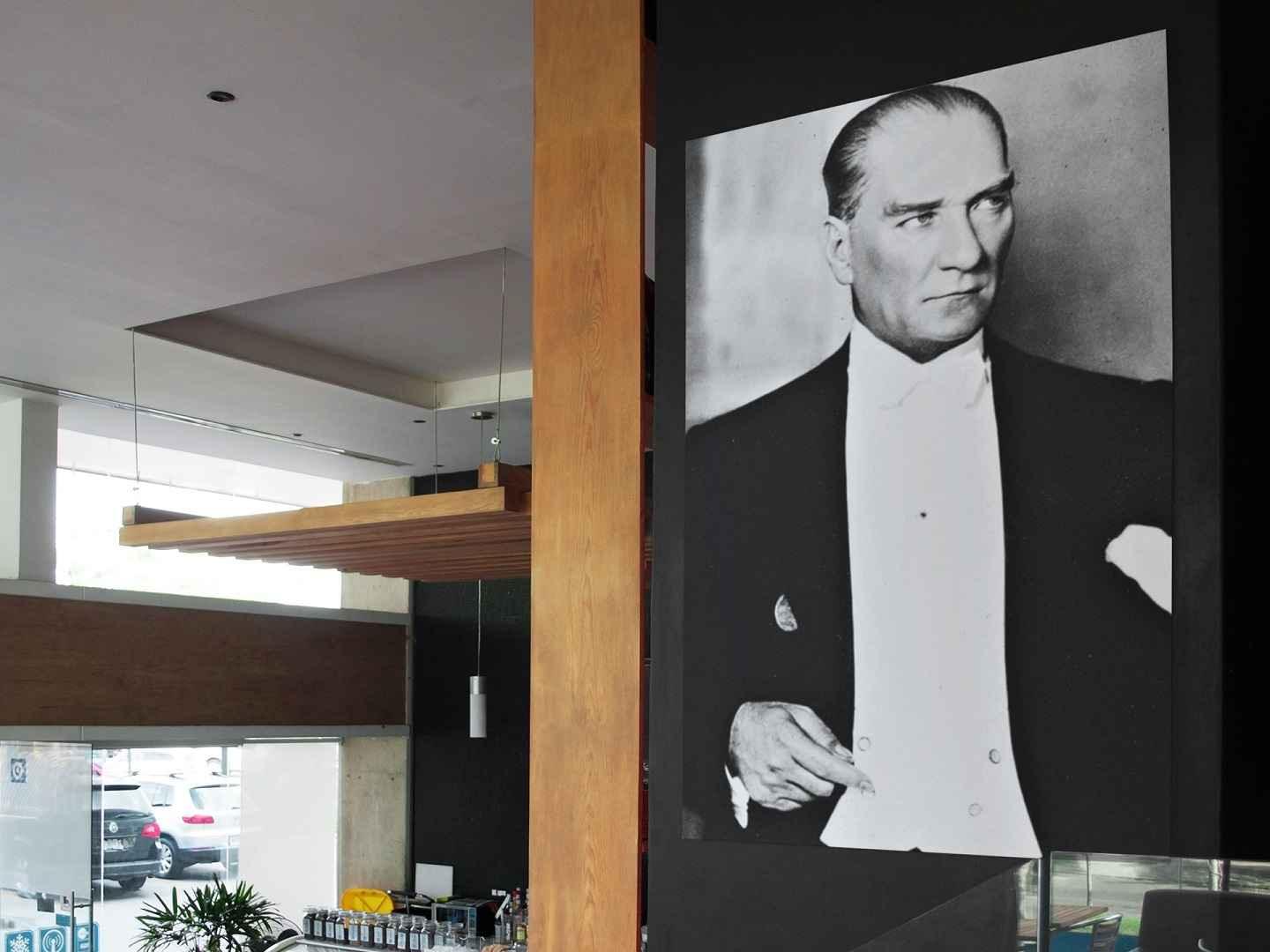 Mustafa Kemal Ataturk print displayed on a wall in a coffee shop.