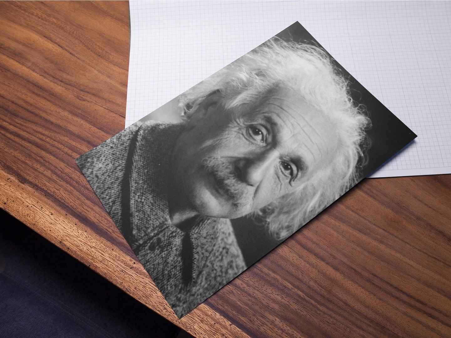 Close-up photo of an Einstein poster lying on a wooden table.