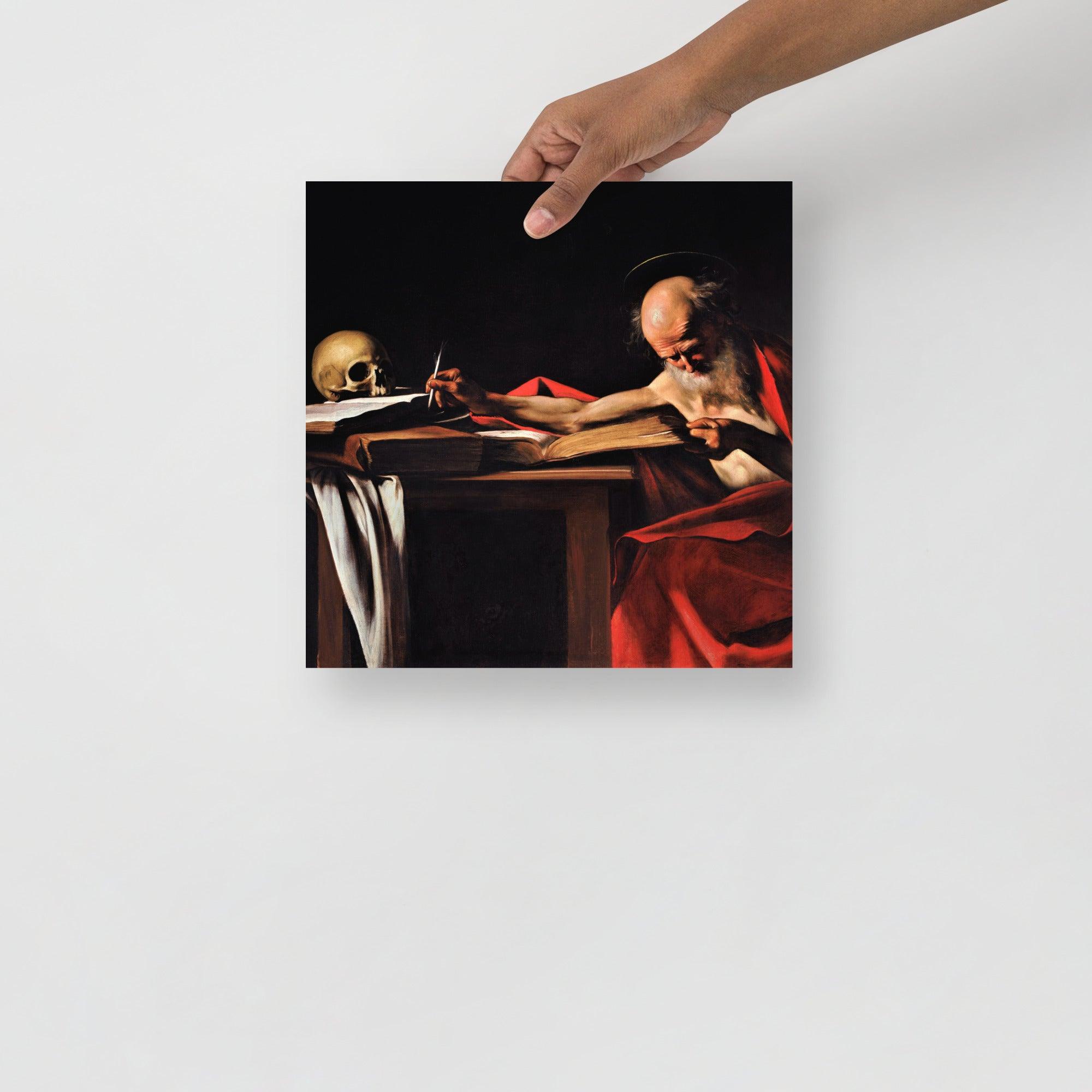 A Saint Jerome Writing by Caravaggio poster on a plain backdrop in size 12x12”.