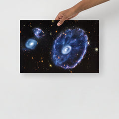 A Cartwheel Galaxy by James Webb Space Telescope poster on a plain backdrop in size 12x18”.