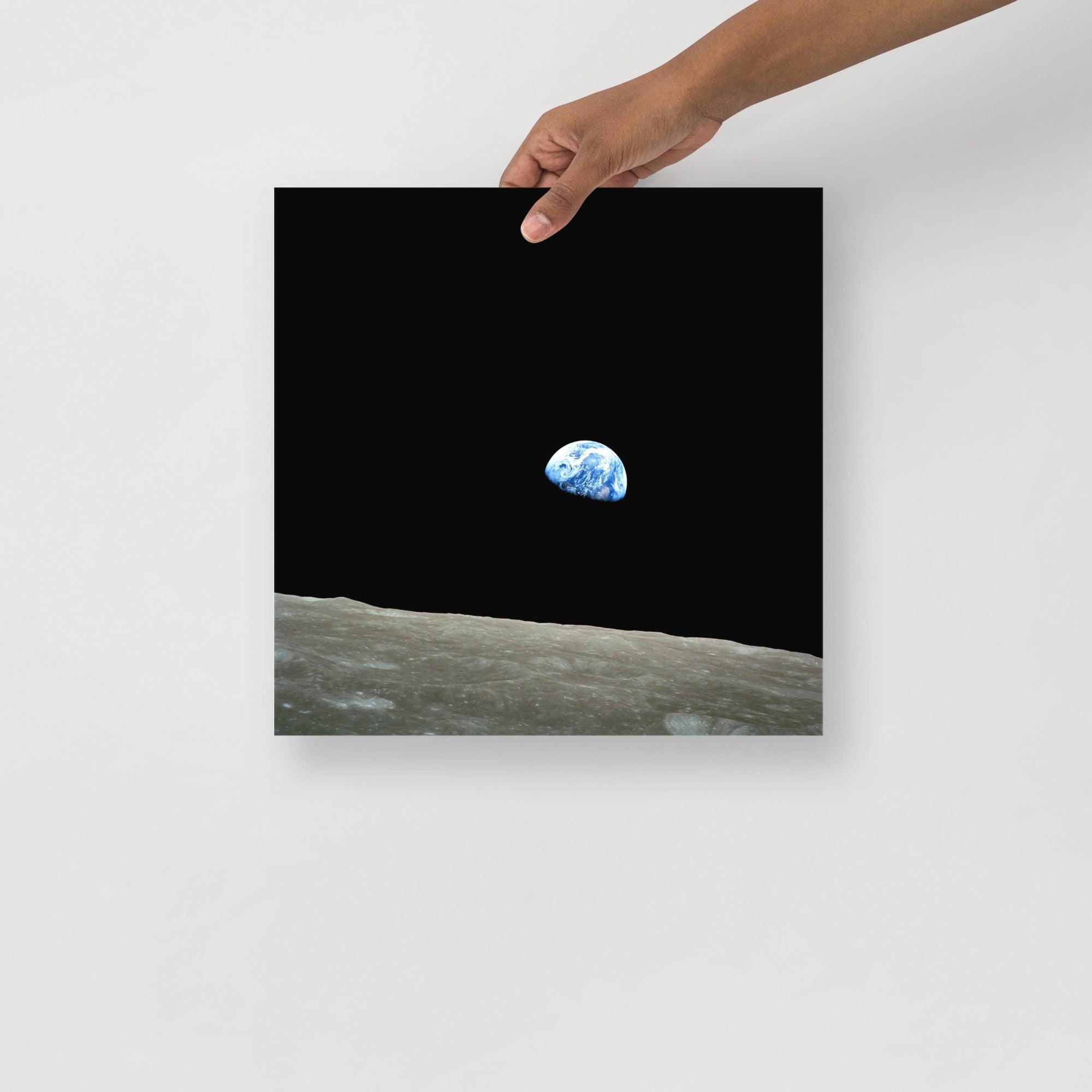 An Earthrise Apollo 8 poster on a plain backdrop in size 14x14”.