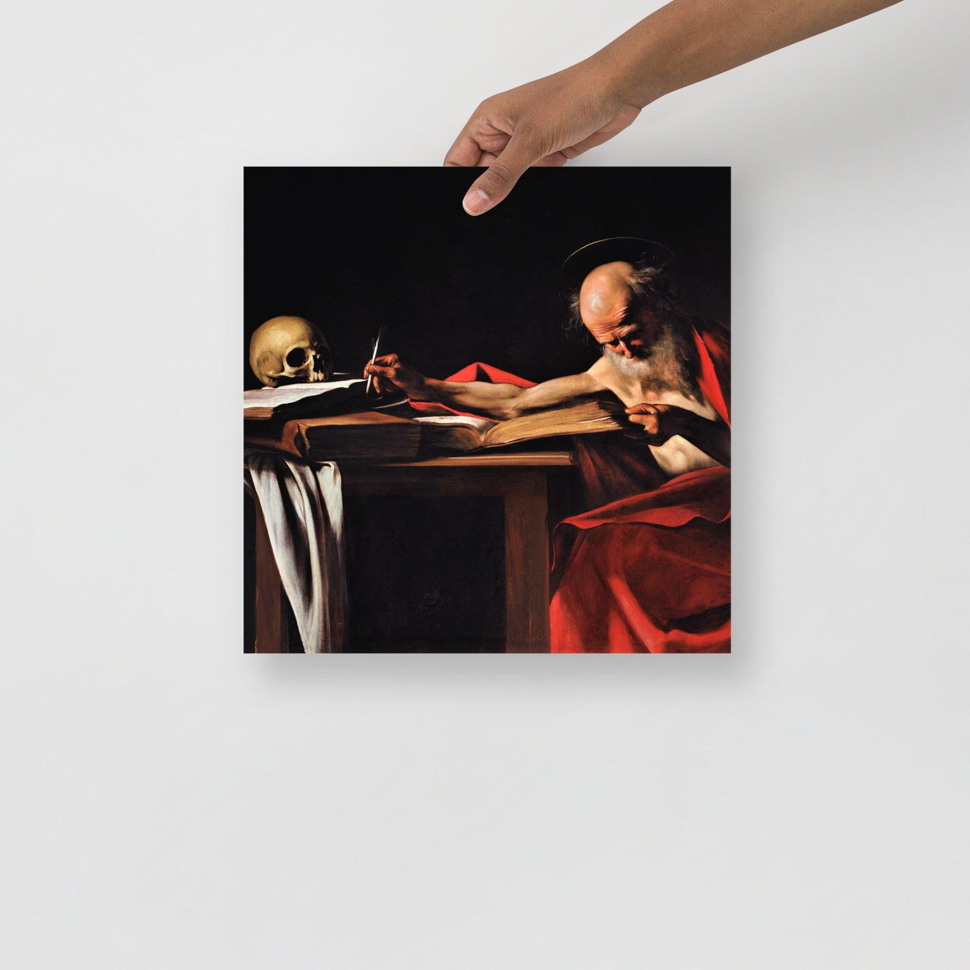 A Saint Jerome Writing by Caravaggio poster on a plain backdrop in size 14x14”.