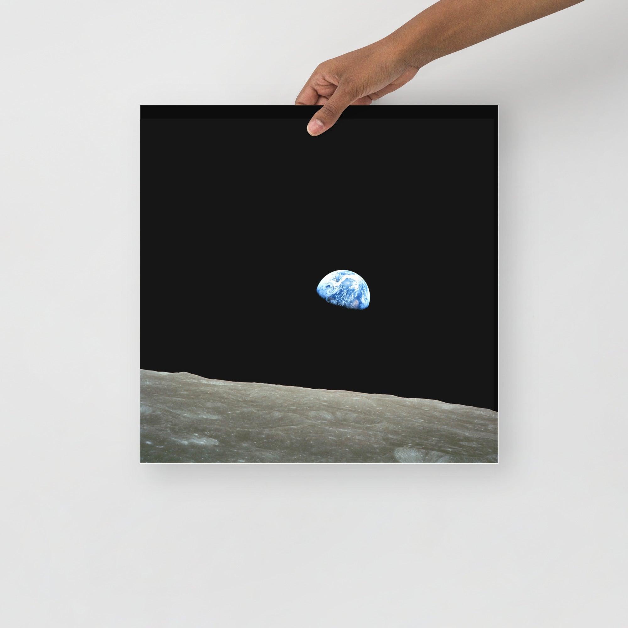 An Earthrise Apollo 8 poster on a plain backdrop in size 16x16”.