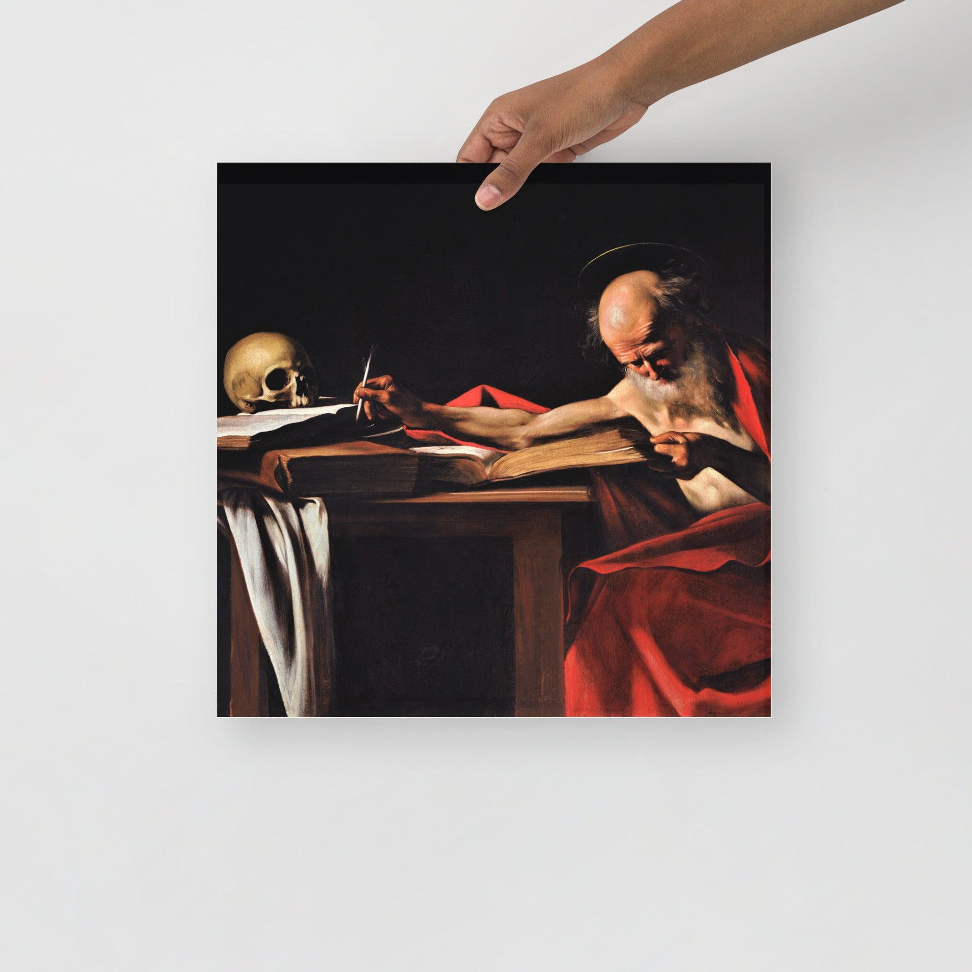 A Saint Jerome Writing by Caravaggio poster on a plain backdrop in size 16x16”.