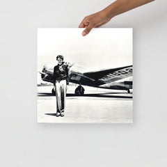 An Amelia Earhart standing in front of the Lockheed Electra on a plain backdrop in size 16x16”.