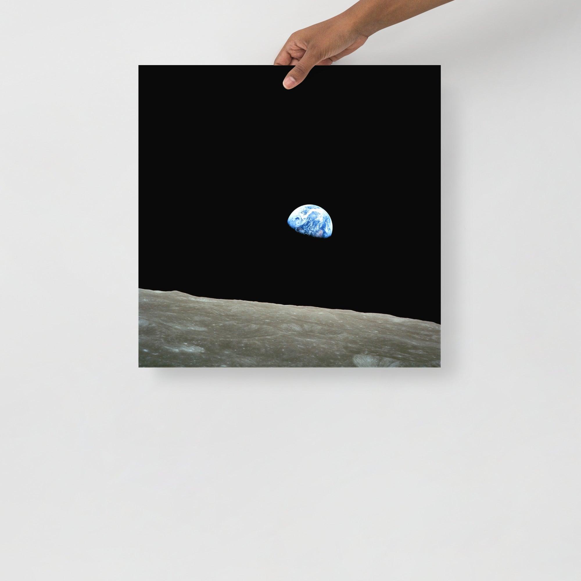 An Earthrise Apollo 8 poster on a plain backdrop in size 18x18”.