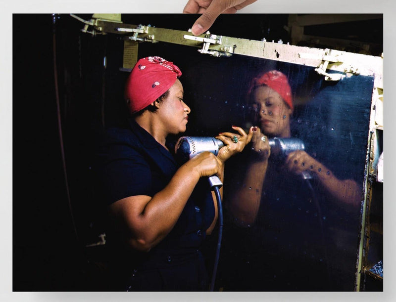 A Rosie the Riveter poster on a plain backdrop in size 18x24”.